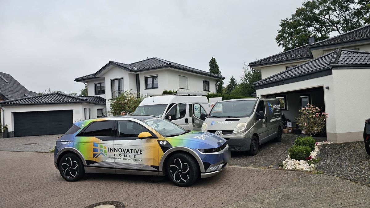 Firmenfahrzeuge von Innovative Homes vor einem Einfamilienhaus
